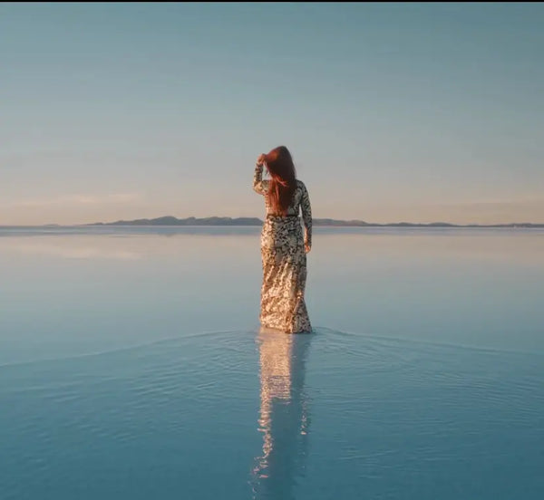 video of a woman walking in water and a woman drinking a glass of water